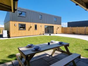 a wooden table in a yard with a house at Dronefield Lodge in Pitney