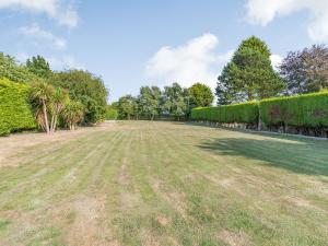 a large grass field with trees and bushes at The Hawthorns in Ottringham