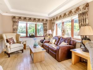 a living room with a leather couch and chairs at The Hawthorns in Ottringham +20 photos