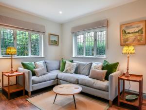 a living room with a couch and two tables at Keeds Cottage in Pulborough