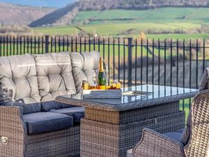 a couch and a table with a bottle of champagne at The Lodge in Wonastow