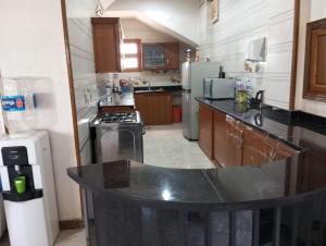 a kitchen with a black counter top in a room at Villa Layan الريف الاوروبي in Madīnat as Sādāt
