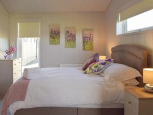 a bedroom with a white bed with two pillows at Willow Lodge - Uk13637 in Creetown