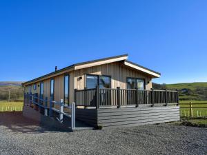 a small house with a porch on a gravel lot at Willow Lodge - Uk13637 in Creetown