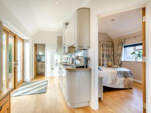 a kitchen and a bedroom with a bed in a room at Larks Nest in Wortham