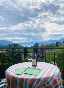 a table with a wine glass sitting on a balcony at VerdeLago casa vacanze in Luino +5 photos