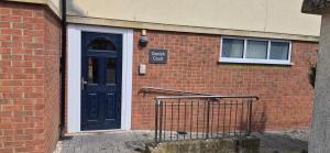 a brick building with a blue door and a sign on it at Cozy 2BR apartment in Maidenhead Sleeps 6 in Maidenhead