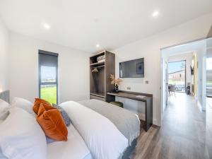 a bedroom with a bed and a desk and a television at Cybi Lodge 6 - Uk42798 in Llangefni