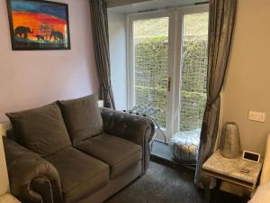 a living room with a couch and a window at Cherrywood Lodge in Looe