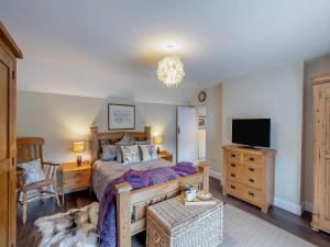 a bedroom with a bed and a flat screen tv at The Old Cottage - Uk49169 in Beadnell +12 photos
