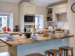 a kitchen with a table with glasses of wine at The Old Cottage - Uk49169 in Beadnell