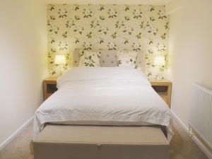 a bedroom with a bed with a flowery wallpaper at Forest Cottage in Northwold