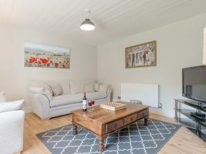 a living room with a couch and a coffee table at Abraham's Cottage in Low Eskcleth