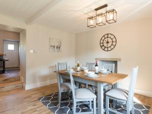a dining room with a wooden table and chairs at Abraham's Cottage in Low Eskcleth +12 photos
