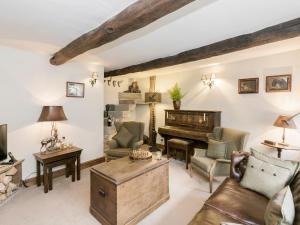 a living room with a piano and a couch at Narrowgates Cottage in Barrowford