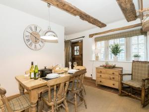 a dining room with a table and chairs and a clock at Narrowgates Cottage in Barrowford +22 photos