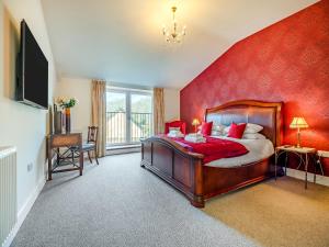 a bedroom with a large bed and a red wall at Old Barn 2 - Uk48478 in Ferndown