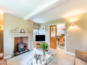 a living room with a fireplace and a television at Adair Cottage in Wigglesworth