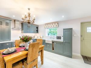 a kitchen with blue cabinets and a wooden table at Adair Cottage in Wigglesworth