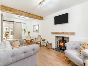 a living room with two couches and a fireplace at Wick Cottage in Nottage