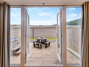 a sliding glass door leading to a patio with a table at Ty Felin - Uk12744 in Acrefair