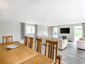 a dining room and living room with a table and chairs at Upper Bryn Y Groes in New Bridge