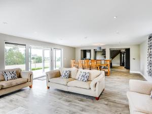 a living room with two couches and a dining room at Upper Bryn Y Groes in New Bridge