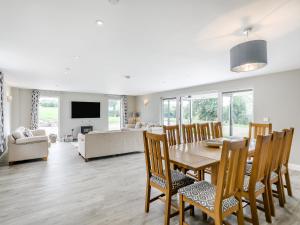 a dining room and living room with a table and chairs at Upper Bryn Y Groes in New Bridge