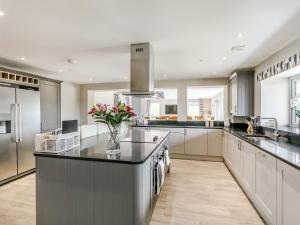 a kitchen with a center island with a vase of flowers at Upper Bryn Y Groes in New Bridge