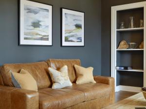 a brown couch in a living room with two pictures at Darroch View in Ballater