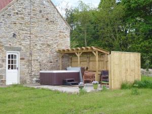 a backyard with a heater and a stone building at Hall Farm Cottage in Byers Green