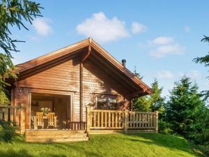 a log cabin with a porch on a green lawn at Henning Lodge - Uk31008 in Ansty