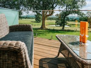 a patio with a table and chairs on a wooden deck at Rue - Uk51100 in Clitheroe