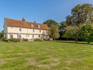 a large grass field in front of a large house at Pattiswick Hall in Stisted