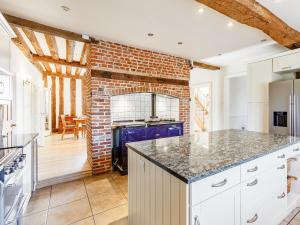 a kitchen with white cabinets and a brick fireplace at Pattiswick Hall in Stisted +18 photos