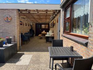 a patio with a table and chairs and a building at B&B Nobel in Buren