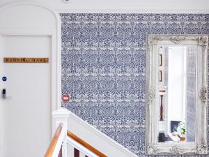 a staircase with blue wallpaper and a mirror at Running Hare - Uk7558 in Inverness