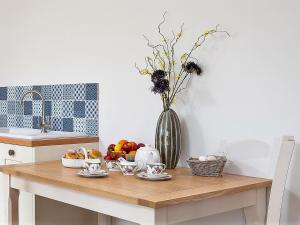 a kitchen table with a vase of flowers and fruit at Barn End - Uk32694 in Horton