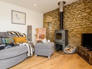 a living room with a couch and a wood stove at Barn End - Uk32694 in Horton