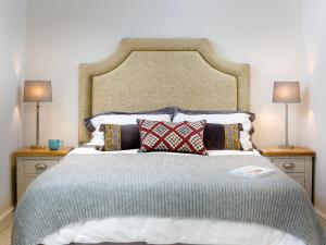 a large bed with pillows and two lamps on tables at Barn End - Uk32694 in Horton
