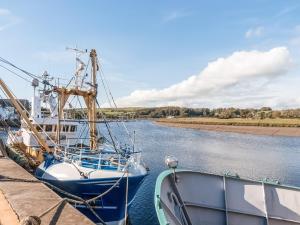 two boats docked at a dock on a river at Auchengool House in Kirkcudbright
