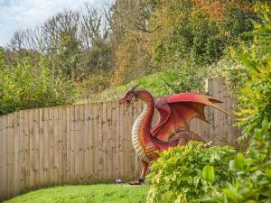 a statue of a dragon standing next to a fence at Y-Beudy Bach - Uk51421 in Llandeilo