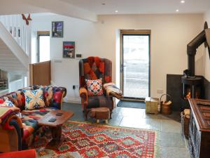 a living room with a couch and chairs and a fireplace at Y-Beudy Bach - Uk51421 in Llandeilo