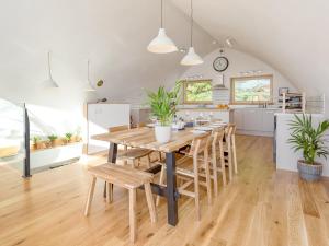 a kitchen and dining room with a wooden table and chairs at Jill Strawbale House- Ukc2935 in Strontian