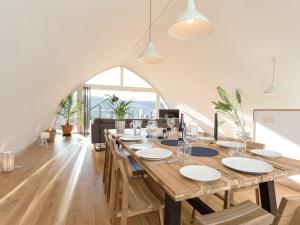 a large wooden table in a living room with a large window at Jill Strawbale House- Ukc2935 in Strontian