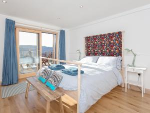 a white bedroom with a bed and a window at Jill Strawbale House- Ukc2935 in Strontian +22 photos