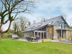 a stone house with a table in the yard at Cwm Hyfryd in Llanboidy +21 photos
