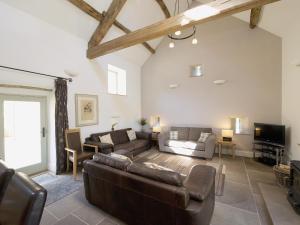 a living room with a couch and a tv at Dale House in Castleton