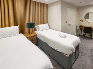 a bedroom with two beds and a desk with a chair at Uk47852 - No 1B in Aberystwyth