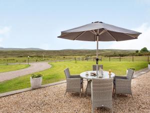 a table and chairs with an umbrella on a patio at Morven View in Dunbeath
